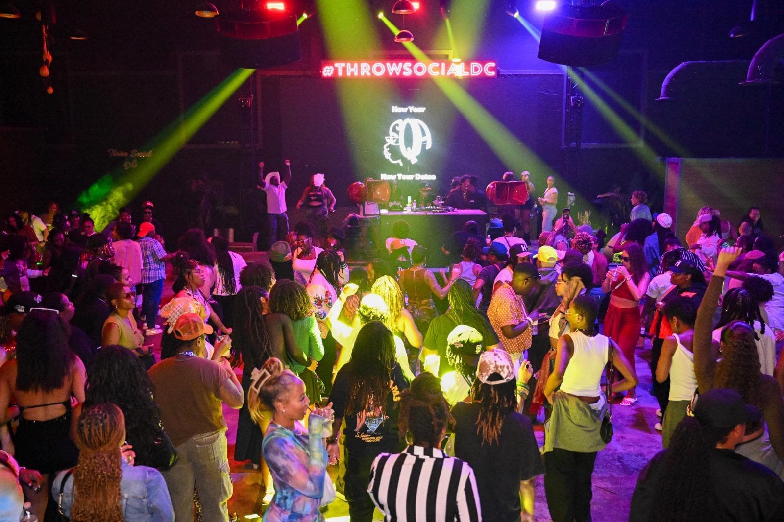A packed dance floor under the LED wall