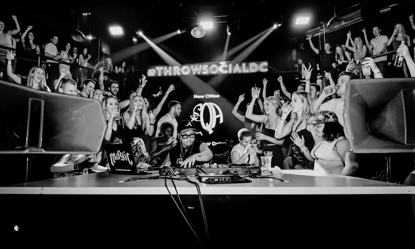 Hands up in front of the booth, in black and white