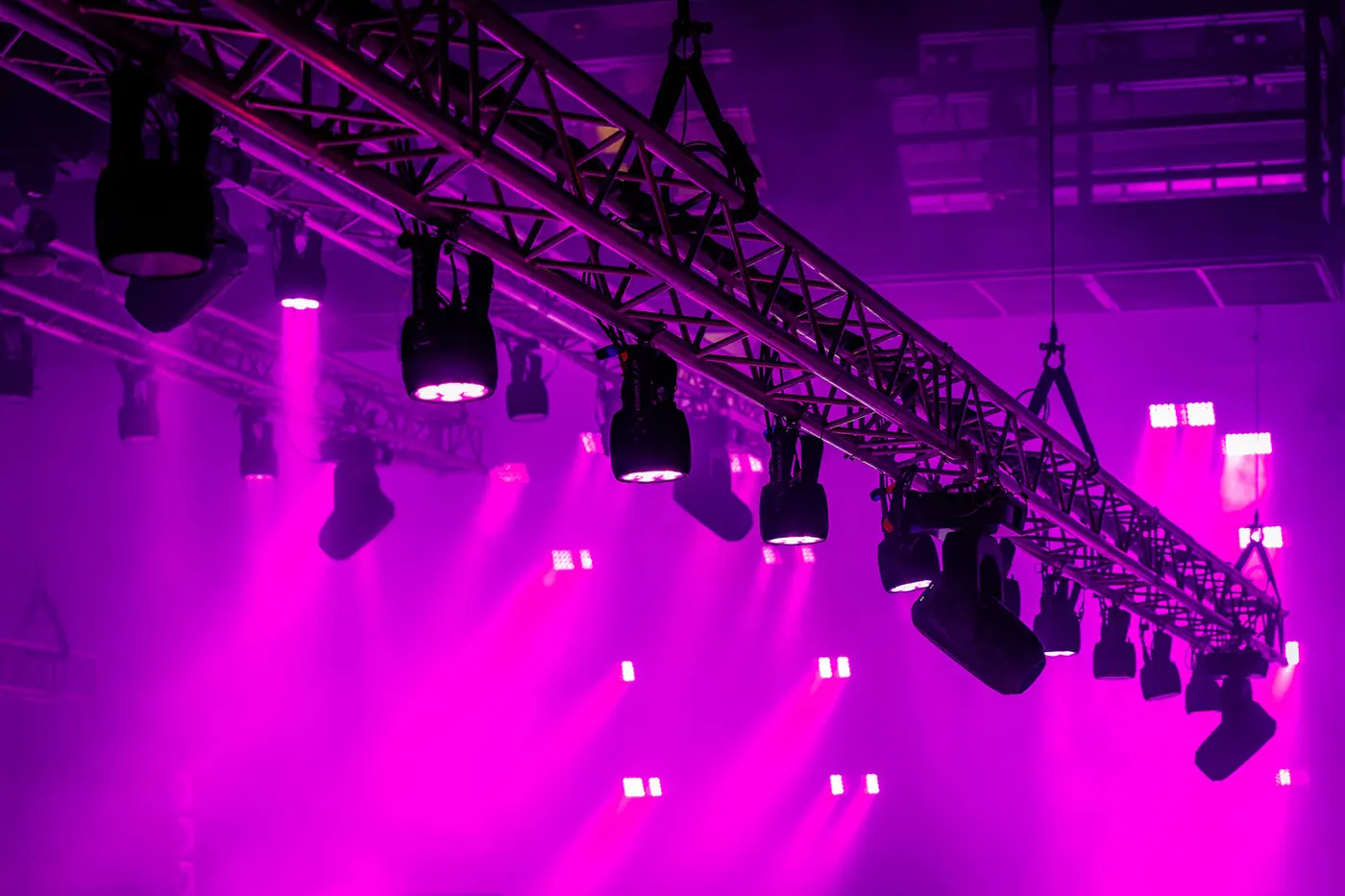 Moving heads hung on truss in magenta light