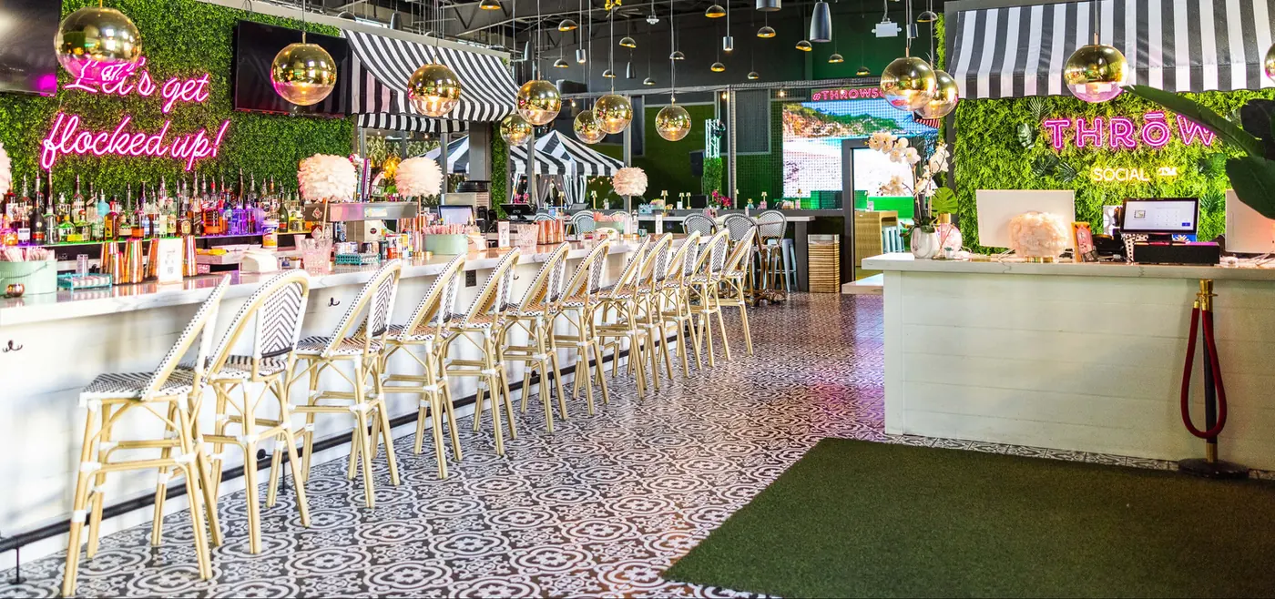 The line bar with pink neon, white stools and a green wall
