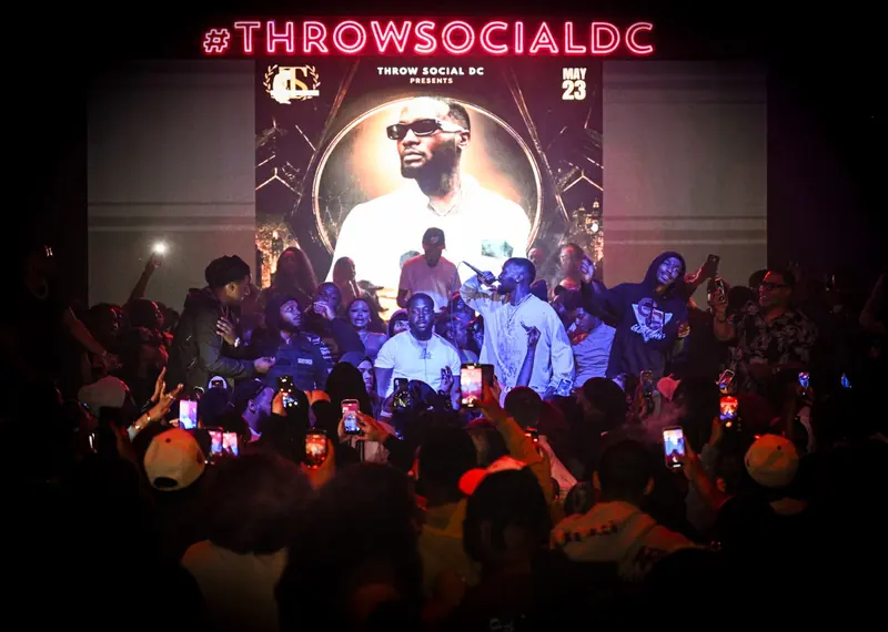 An artist on stage in front of the LED wall and a packed crowd